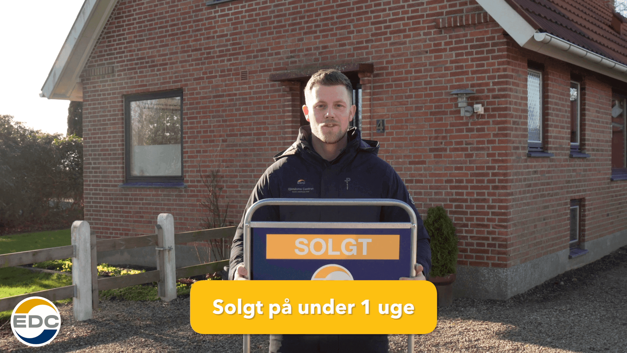 EDC-mægler med SOLGT-skilt foran ejendom