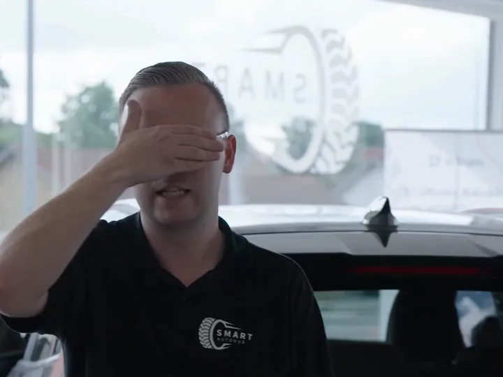 Mads fra Smart Autohus holder hånden for øjnene under en blindtest i showroomet